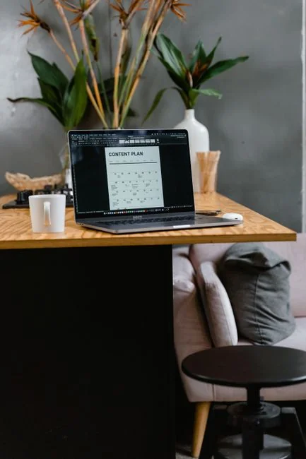 services-04 A contemporary workspace with hands reviewing marketing data on a laptop alongside printed documents.